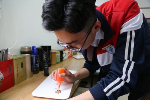 福州第一技师学院，学习烹饪专业的定西籍贫困学生林彦强正在宿舍练习做盘饰 。本报记者杨晓军摄